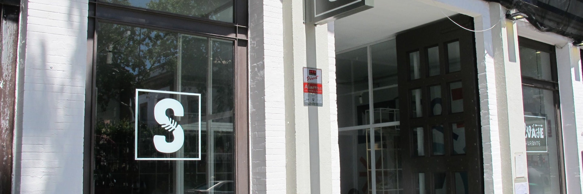 Facade of Salvaje restaurant with S sign in window.
