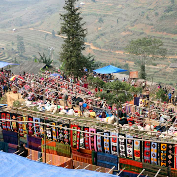 Vietnam, near Bac Ha, Flower Hmong brightly coloured fabrics for sale at Can Cau market