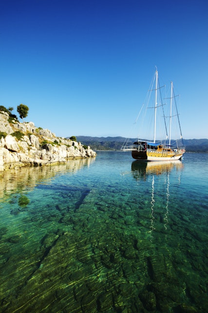 Gulet sailing boat near sunken remains of Lycian town on coast of Kekova Island.
