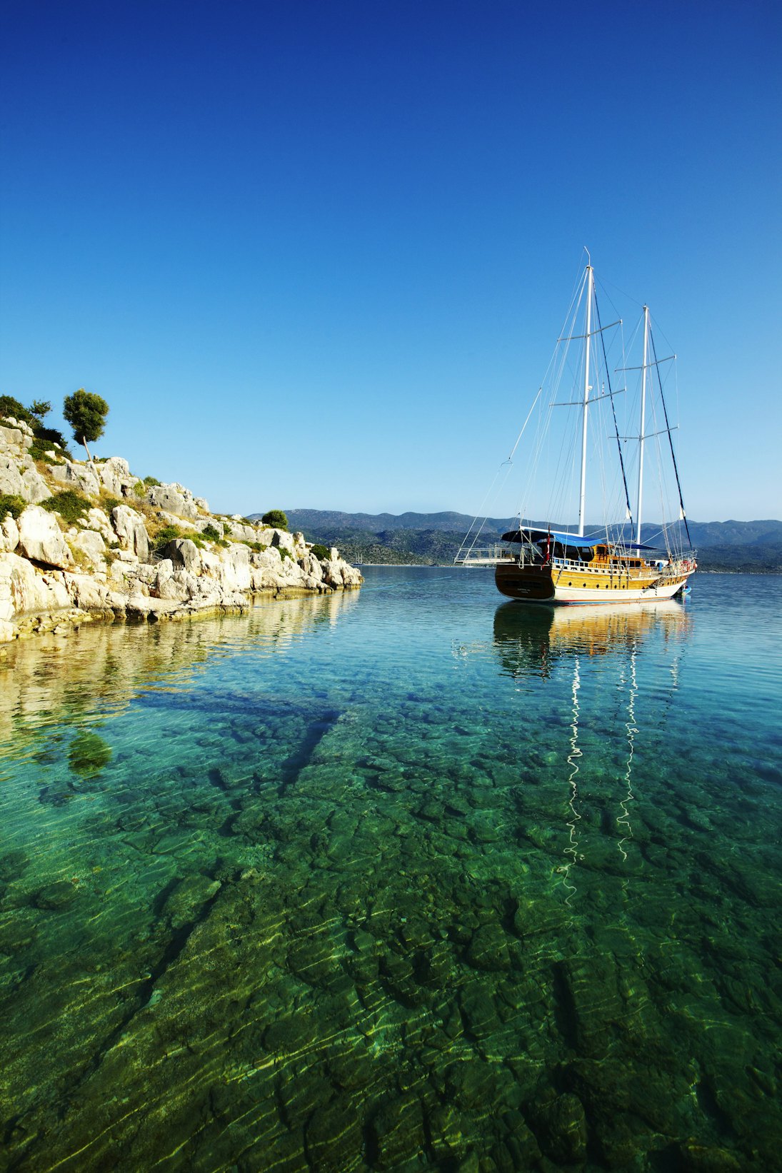 Gulet sailing boat near sunken remains of Lycian town on coast of Kekova Island.