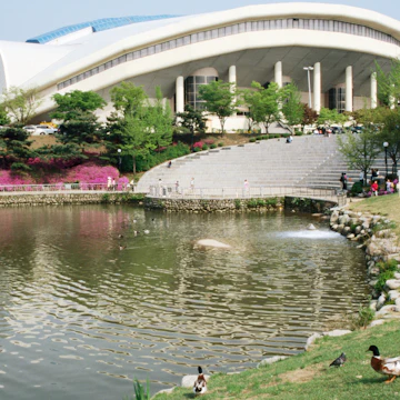 Olympic Park with pond and ducks in foreground.