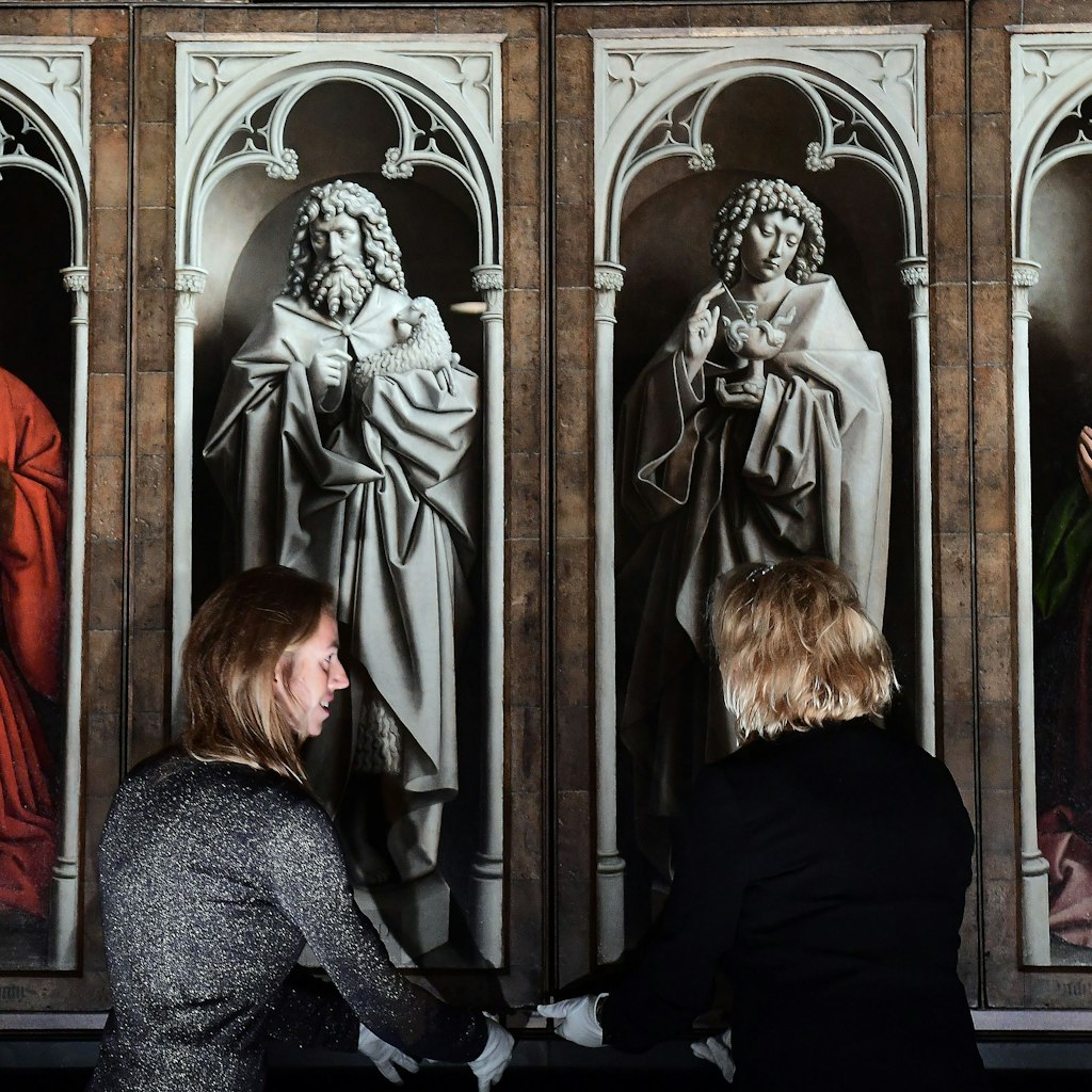 Officials unveil the restored exterior panels of "The Adoration of the Mystic Lamb", an altar piece painted by the Van Eyck brothers in 1432, at Saint Bavo Cathedral in Ghent on October 12, 2016. .The restoration of the exterior panels and frames started in 2012, and constitutes the first phase of restauration which will be followed by two other phases for the interior panels and is set to last until 2020. / AFP / EMMANUEL DUNAND        (Photo credit should read EMMANUEL DUNAND/AFP/Getty Images)
