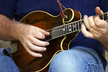 Musician from Cumberland Highlanders playing his mandolin on porch of Bill Monroe Homeplace, Jerusalem Ridge, Rosine.