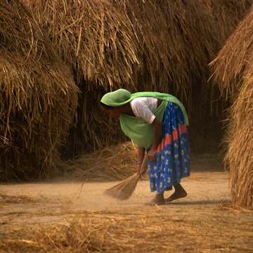 A Tharu woman sweeping.