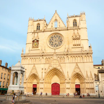 LYON, FRANCE - JUNE 5: Exterior of St. John the Baptist cathedal in Lyon downtown with people passing by. June 2015; Shutterstock ID 405341626; Your name (First / Last): Daniel Fahey; GL account no.: 65050; Netsuite department name: Online Editorial; Full Product or Project name including edition: Lyon BiT