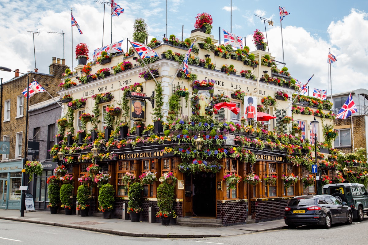 LONDON, UK - 28TH JUNE 2016: A view of the outside of the Churchill Arms in London. Large amounts of flowers and UK decorations can be seen on the exterior.; Shutterstock ID 449355649; Your name (First / Last): Lauren Gillmore; GL account no.: 56530; Netsuite department name: o; Full Product or Project name including edition: 65050/ Online Design /LaurenGillmore/POI
