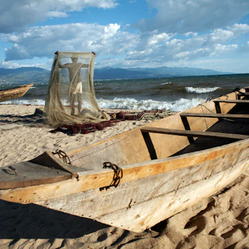 A fisherman tends his nets on Plage des Cocotiers (Coconut Beach) also known as Saga Beach, Lake Tanganyika, Bujumbura, Burundi, East Africa, Africa