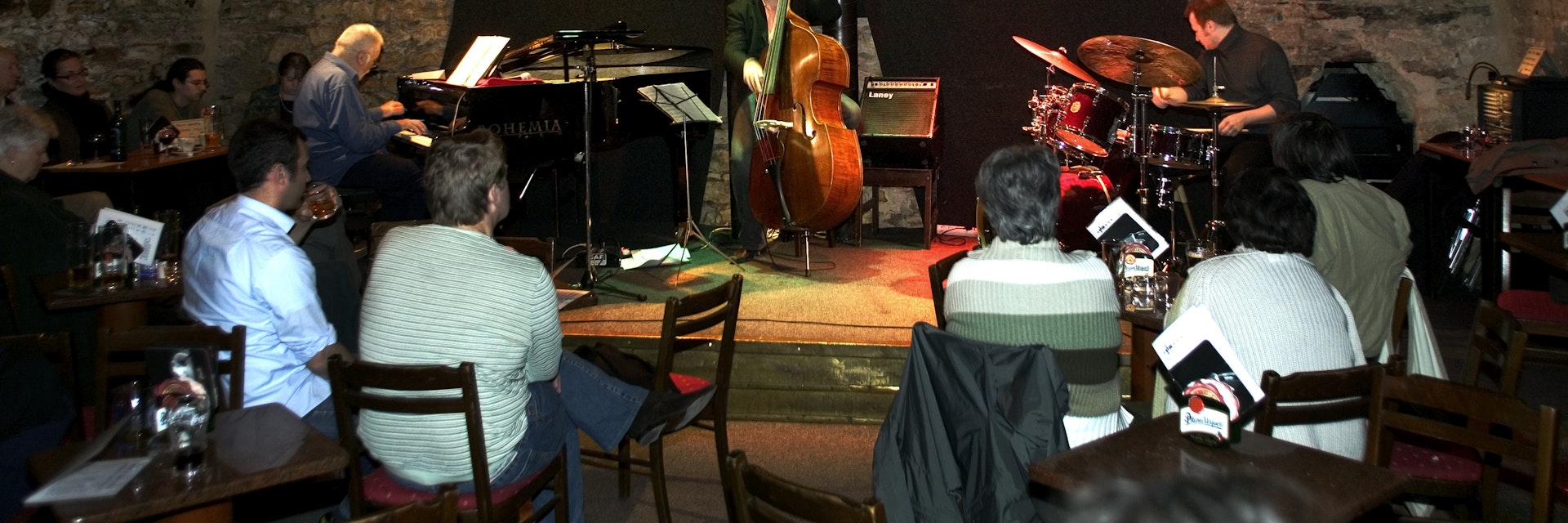 Band playing piano, double bass and drums to audience, Agharta Jazz Club.