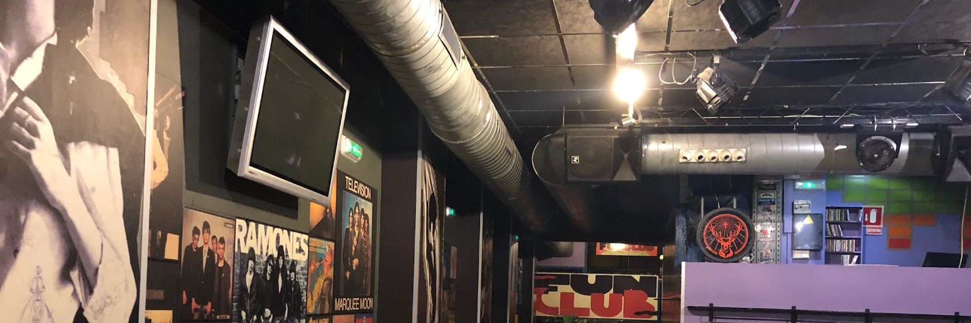 Fun Club posters on wall, DJ box, name at far end