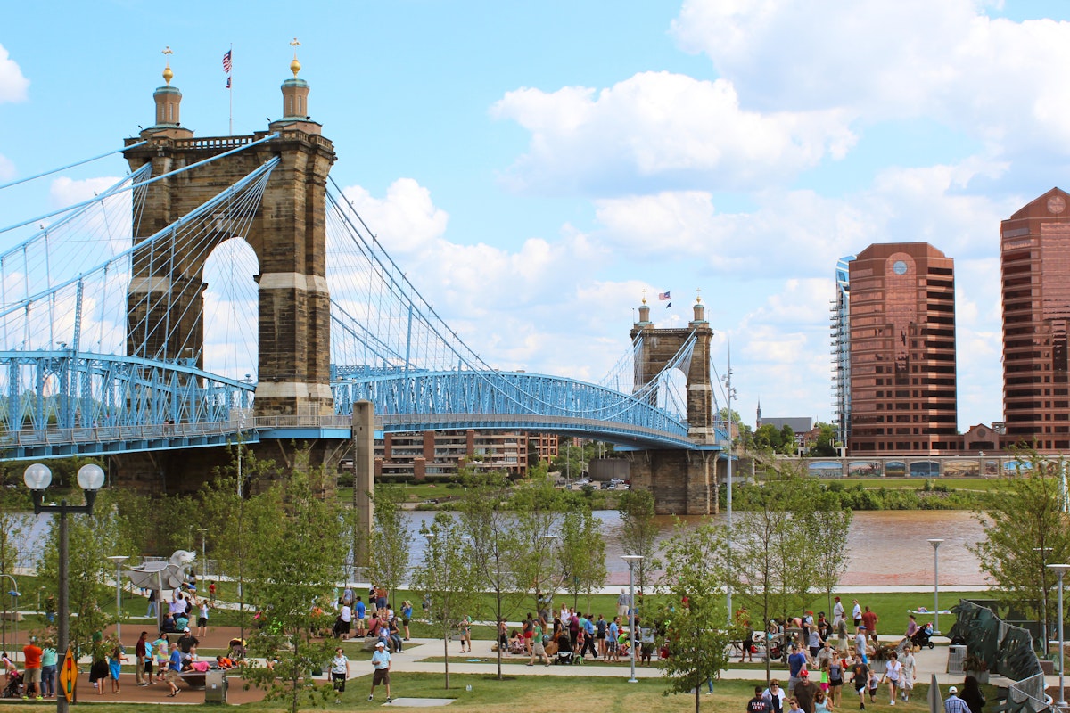 A landscape view of Cincinnati's Smale Riverfront Park and the Roebling Suspension Bridge that crosses over the Ohio River and connects Cincinnati, Ohio to Covington, Kentucky.