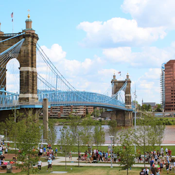 A landscape view of Cincinnati's Smale Riverfront Park and the Roebling Suspension Bridge that crosses over the Ohio River and connects Cincinnati, Ohio to Covington, Kentucky.