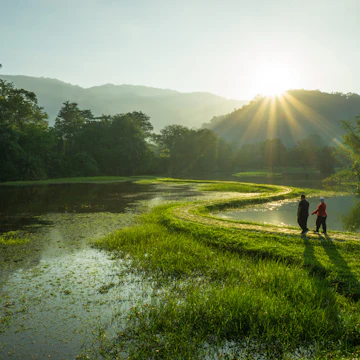 Couple walking at the pathway of "S - Curve" in early morning at Taman Tasik Taiping, Perak, Malaysia.