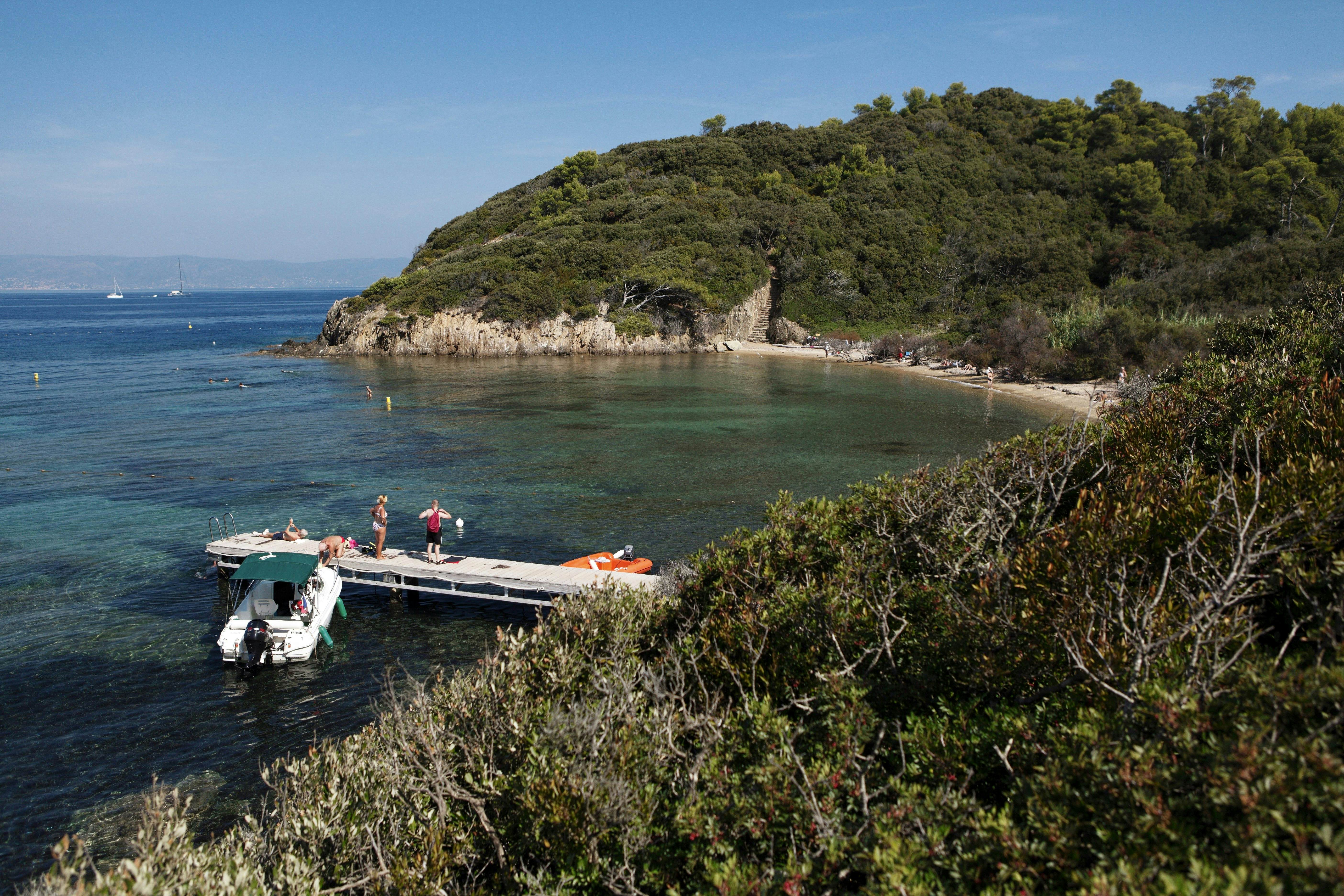 People on jetty in secluded cove on Port-Cros island.