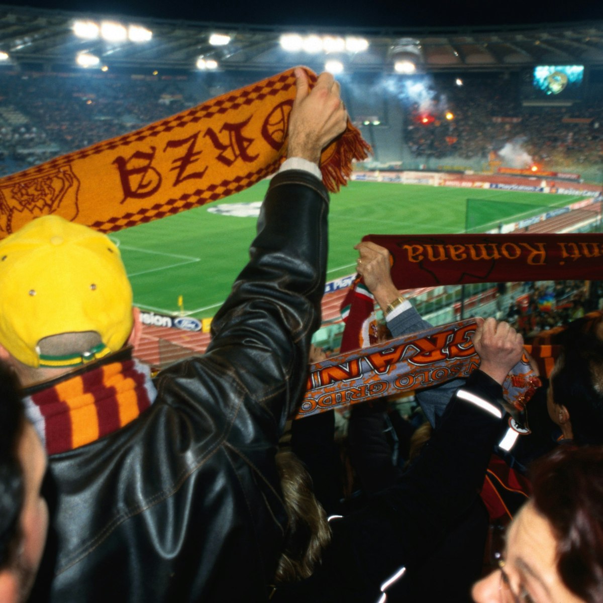 Soccer fans waving scarves at AS Roma versus Ajax Amsterdam match at Champions League Game Stadio Olimpico.