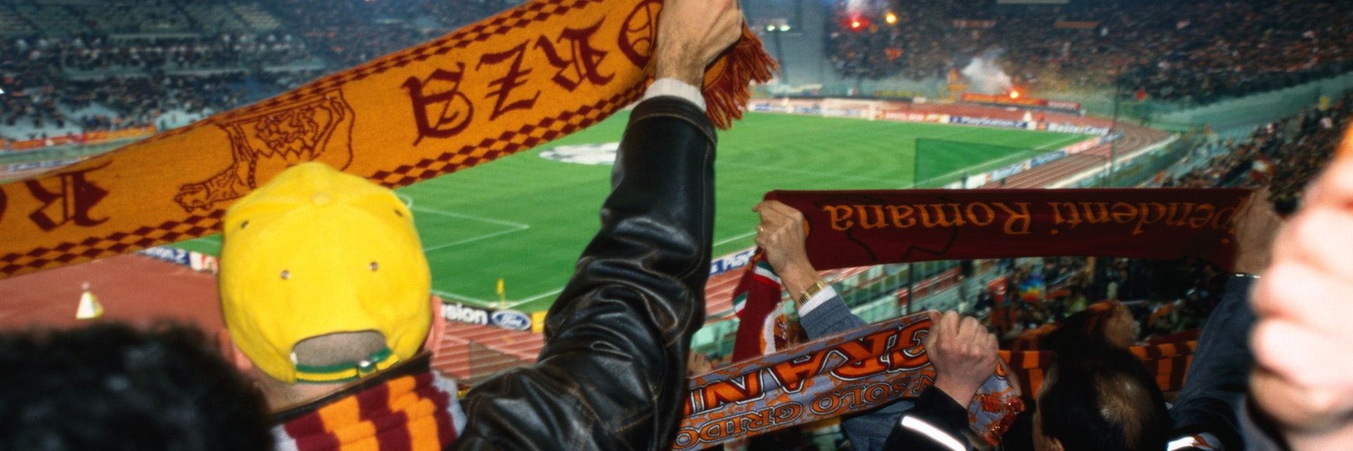 Soccer fans waving scarves at AS Roma versus Ajax Amsterdam match at Champions League Game Stadio Olimpico.