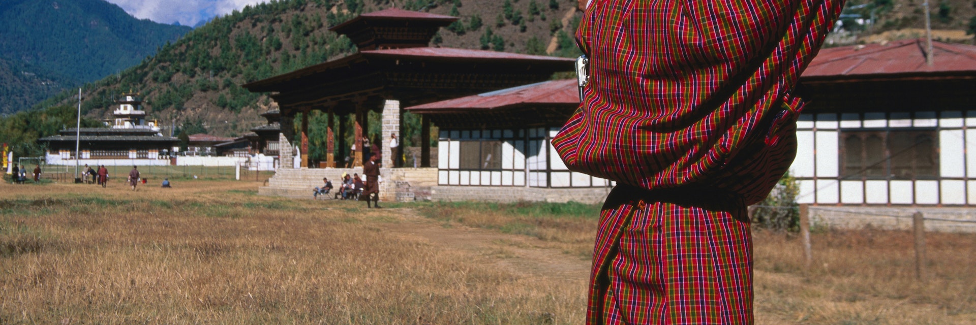 Archer in traditional dress drawing bow in archery competition at national archery ground, Changlimithang Stadium.