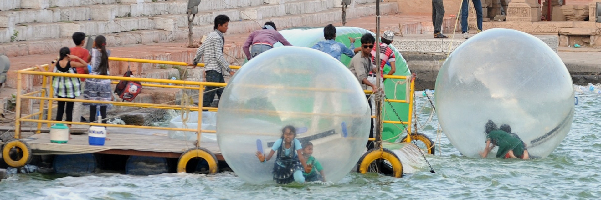 Youths enjoy a ride in floating spheres as tourists throng Kankaria Lake in Ahmedabad on June 3, 2012. Heatwave conditions persist over much of India as the country's expected moonsoon, crucial to farmers and growth in Asia's third-largest economy, has missed its normal arrival date but forecasters said they were confident the rains would arrive soon. Normally the rains begin sweeping across the subcontinent from June 1 to late September and in recent years they have started early.  AFP PHOTO / Sam PANTHAKY        (Photo credit should read SAM PANTHAKY/AFP/GettyImages)