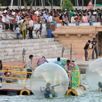 Youths enjoy a ride in floating spheres as tourists throng Kankaria Lake in Ahmedabad on June 3, 2012. Heatwave conditions persist over much of India as the country's expected moonsoon, crucial to farmers and growth in Asia's third-largest economy, has missed its normal arrival date but forecasters said they were confident the rains would arrive soon. Normally the rains begin sweeping across the subcontinent from June 1 to late September and in recent years they have started early. AFP PHOTO / Sam PANTHAKY (Photo credit should read SAM PANTHAKY/AFP/GettyImages)