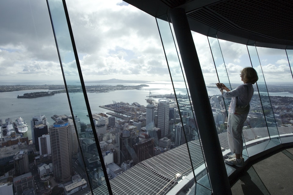 Woman takes photograph from atop Auckland Sky Tower.