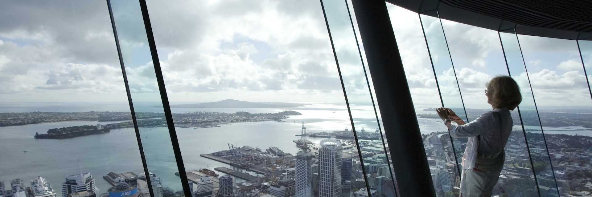 Woman takes photograph from atop Auckland Sky Tower.