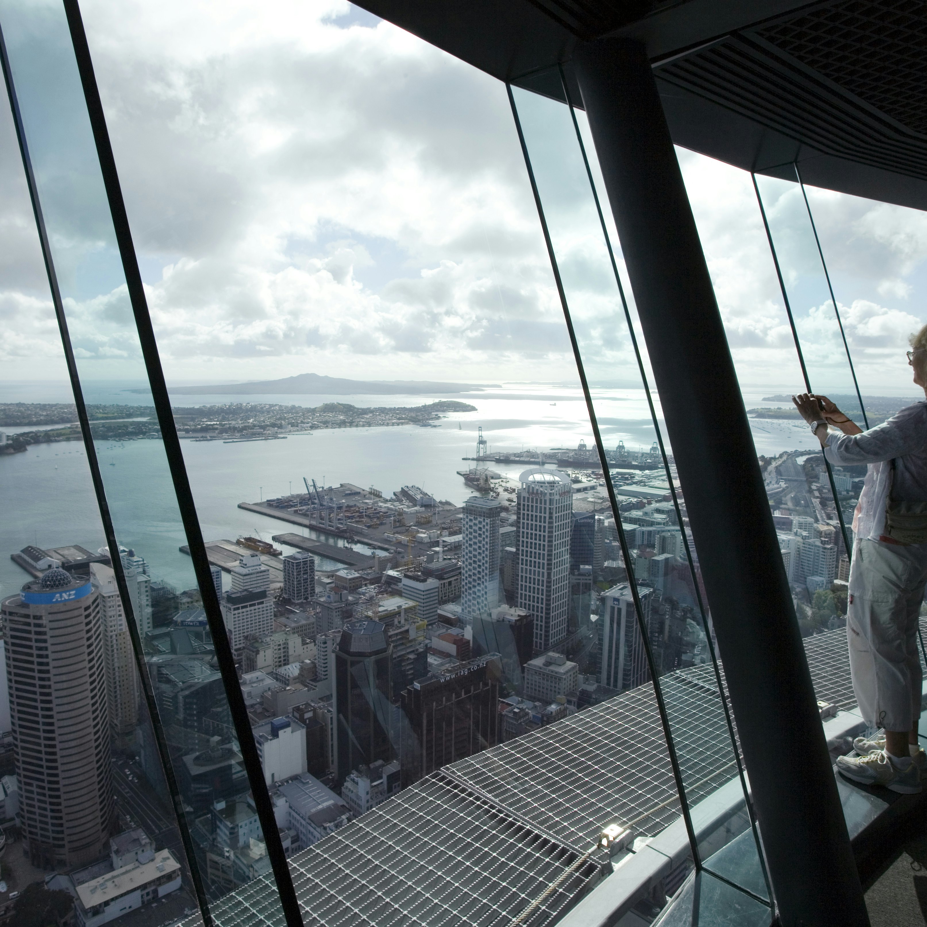 Woman takes photograph from atop Auckland Sky Tower.