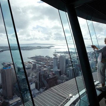 Woman takes photograph from atop Auckland Sky Tower.