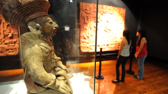 Visitors learn about the Mayas at the Museum of National Identity in Tegucigalpa on December 14, 2012. The beginning of a new Mayan era on December 21 will be marked with celebrations throughout southern Mexico and Central America. Honduras is one of five countries preparing to observe the date, which marks the end of a more than 5,000-year era, according to the Mayan "Long Count" calendar, which began in 3114 BC.  AFP PHOTO/Orlando SIERRA        (Photo credit should read ORLANDO SIERRA/AFP/Getty Images)