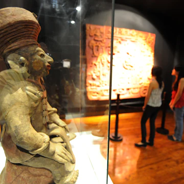 Visitors learn about the Mayas at the Museum of National Identity in Tegucigalpa on December 14, 2012. The beginning of a new Mayan era on December 21 will be marked with celebrations throughout southern Mexico and Central America. Honduras is one of five countries preparing to observe the date, which marks the end of a more than 5,000-year era, according to the Mayan "Long Count" calendar, which began in 3114 BC. AFP PHOTO/Orlando SIERRA (Photo credit should read ORLANDO SIERRA/AFP/Getty Images)