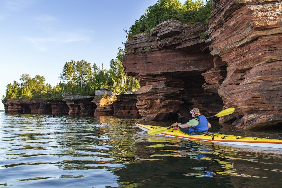 Kayaker exploring sea caves of Devils Island in Apostle Islands National Lakeshore, Wisconsin, USA