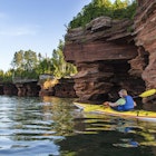 Kayaker exploring sea caves of Devils Island in Apostle Islands National Lakeshore, Wisconsin, USA