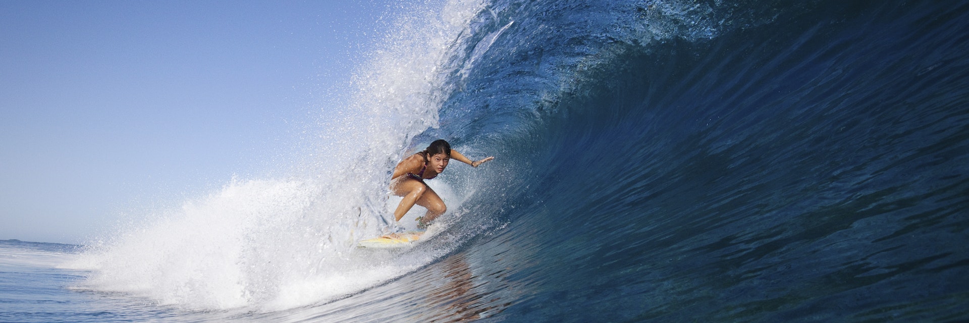 Woman surfing in crest of wave