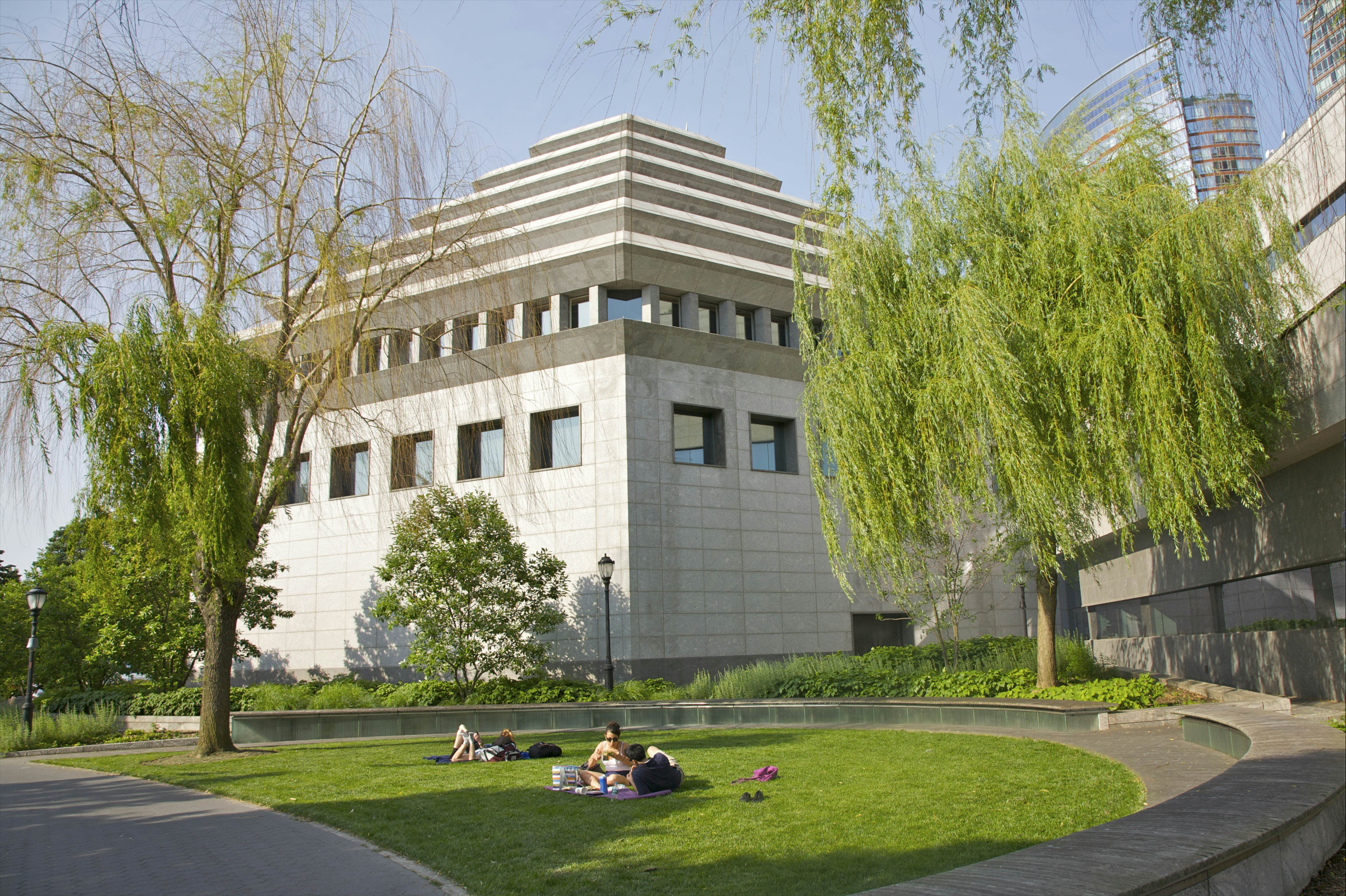 People on lawn near ziggurat building