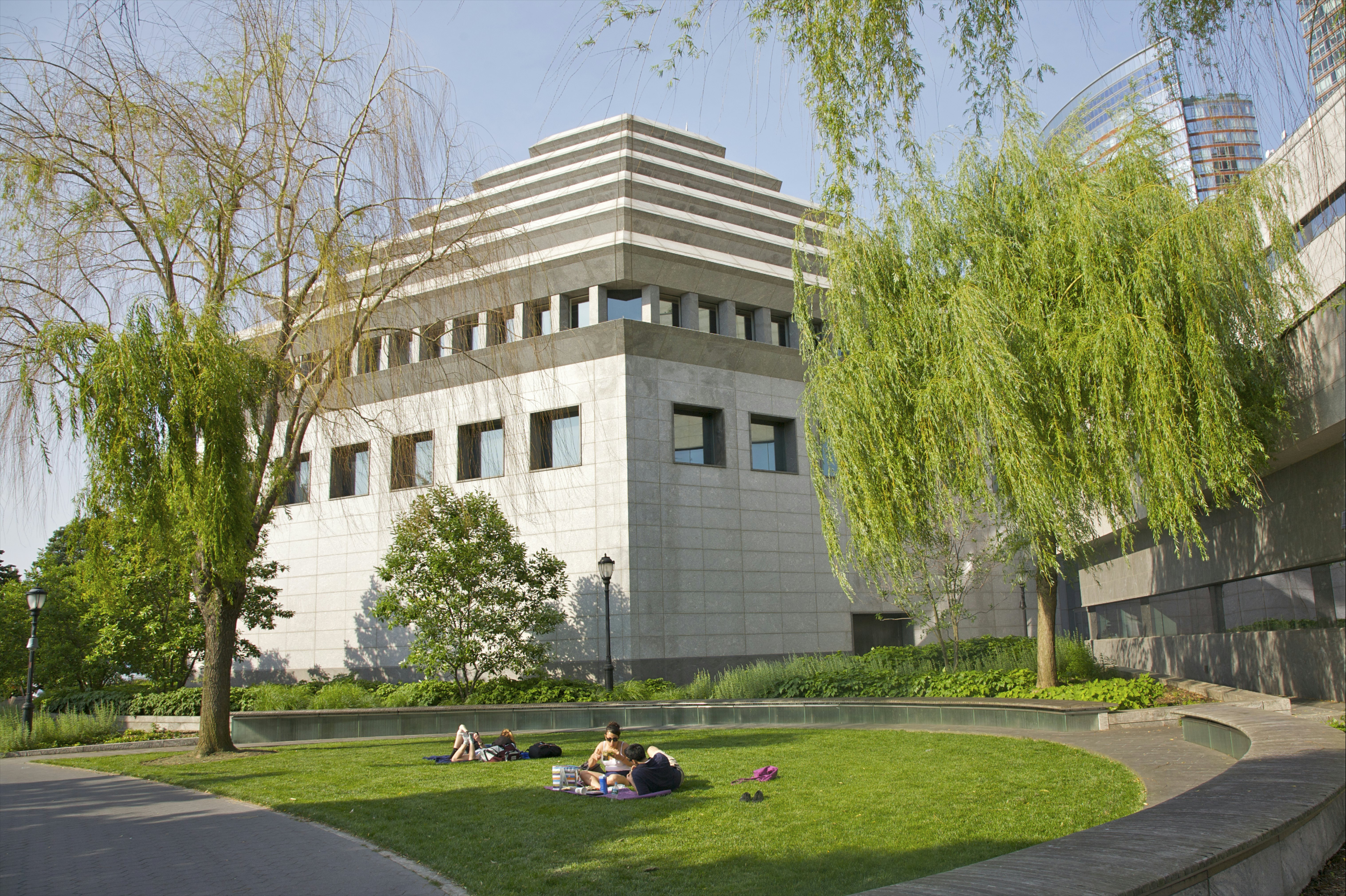 People on lawn near ziggurat building
