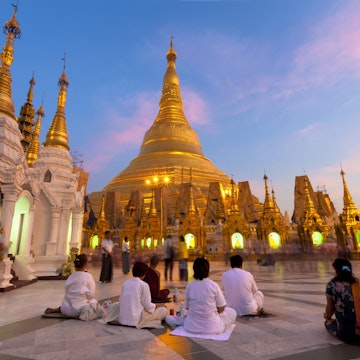 Shwedagon Paya (Pagoda) at dusk with Buddhist worshippers praying, Yangon (Rangoon), Myanmar (Burma), Asia