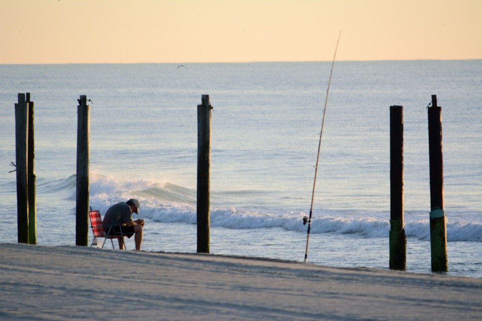 [UNVERIFIED CONTENT] A fisherman dozes off on a beach chair near his fishing pole at Seaside Park, New Jersey, Jersey Shore around sunrise on July 31, 2013.