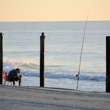 [UNVERIFIED CONTENT] A fisherman dozes off on a beach chair near his fishing pole at Seaside Park, New Jersey, Jersey Shore around sunrise on July 31, 2013.