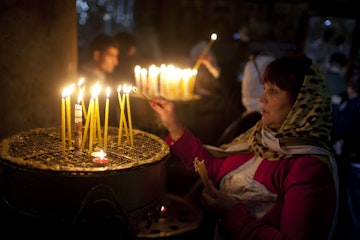 BETHLEHEM, WEST BANK - DECEMBER 24:  Visitors light candles in the Church of the Nativity on December 24, 2014 in Bethlehem, West Bank. Every Christmas pilgrims travel to the church where a gold star embedded in the floor marks the spot where Jesus was believed to have been born.  (Photo by Lior Mizrahi/Getty Images)