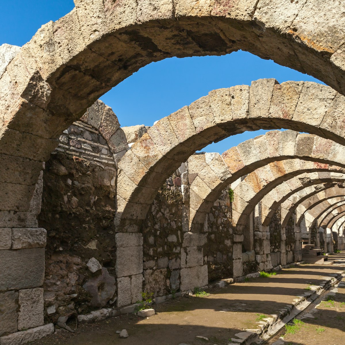 Empty corridor with arcs and blue sky. Ruins of Smyrna