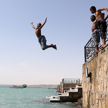 Young Iranians dive into Gulf waters in Chabahar city, south of Iran on May 11, 2015. AFP PHOTO/ ATTA KENARE        (Photo credit should read ATTA KENARE/AFP/Getty Images)