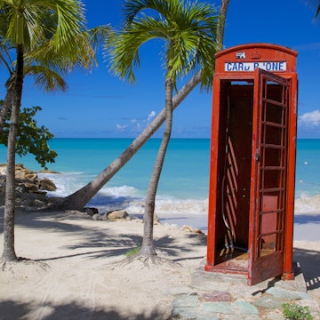 Beach and red telephone box, Dickenson Bay, St. Georges, Antigua, Leeward Islands, West Indies, Caribbean, Central America
