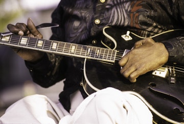 American Blues musician CeDell Davis plays guitar on the Blues Alley Main Stage at the 13th Annual Sunflower River Blues and Gospel Festival, Clarksdale, Mississippi, August 11, 2000. Davis uses a butter knife as a slide, a method he learned overcoming a childhood bout of polio. (Photo by Linda Vartoogian/Getty Images)