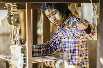Asian girl weaving fabric