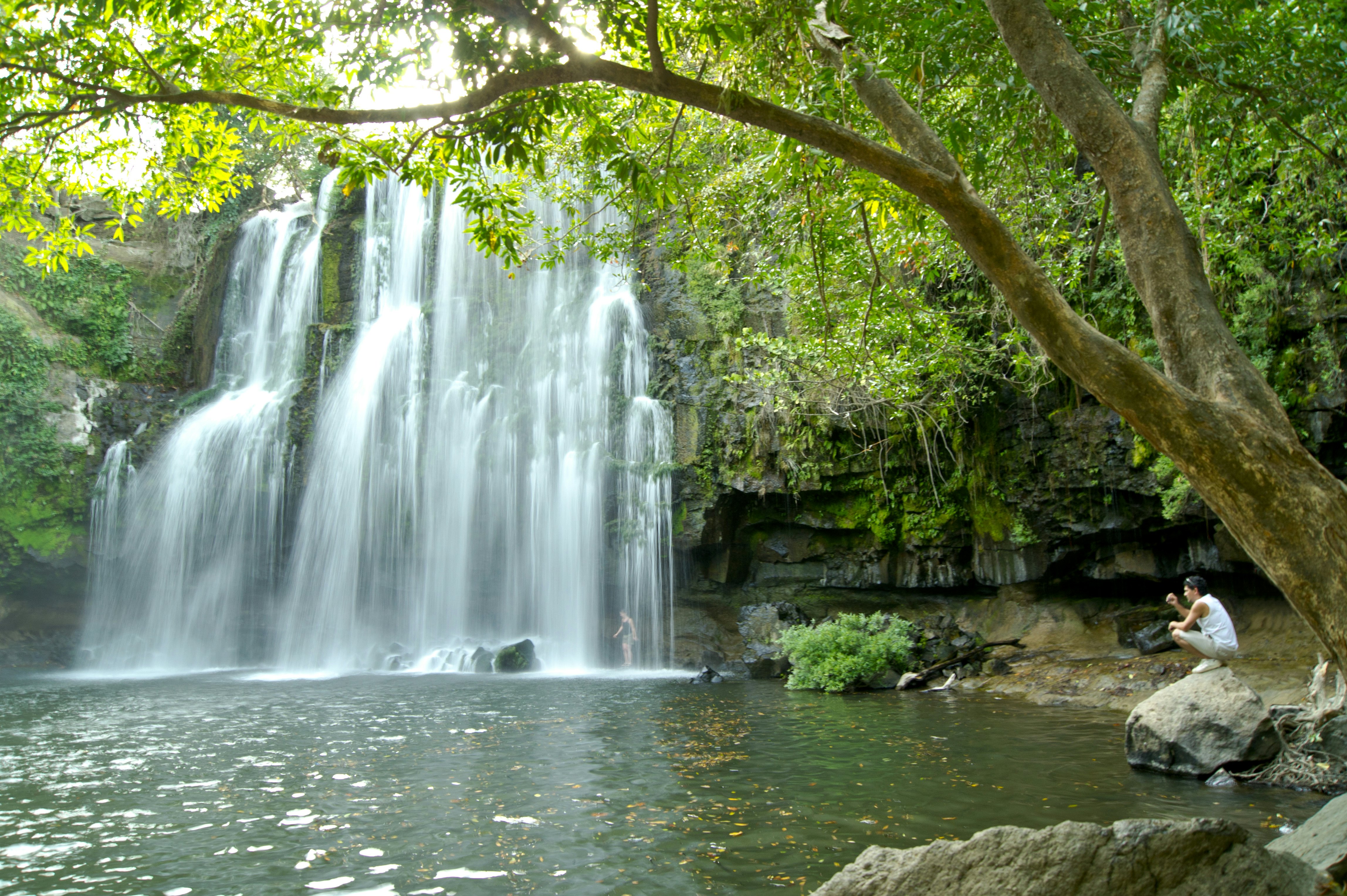Man relaxing next to a waterfall