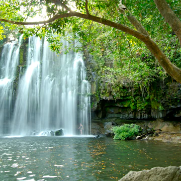 Man relaxing next to a waterfall