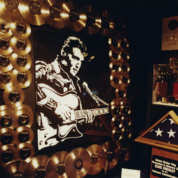 (GERMANY OUT) Presley, Elvis *08.01.1935-16.08.1977+Saenger, Schauspieler, USA - seine Villa 'Graceland' in Memphis, Tennessee (Innenansicht): goldene Schallplatten umkraenzen ein Elvis-Portrait- Januar 1997 (Photo by Sabine Wolf/ullstein bild via Getty Images)