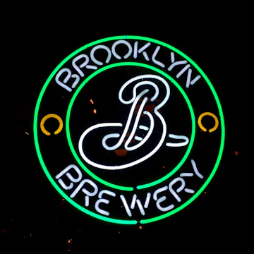Neon sign at night: The Brooklyn Brewery beer logo is displayed in the front window of a bar in Prospect Heights, Brooklyn, NYC- February 28, 2015