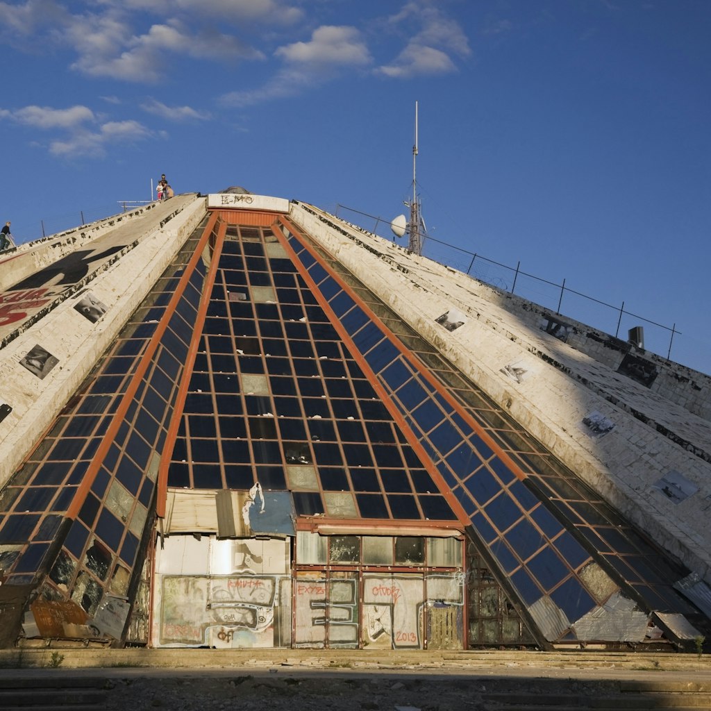 Adults and children climbing up the side of the Pyramid building that housed the former Enver Hoxha Museum, Tirana, Albania, Eastern Europe
