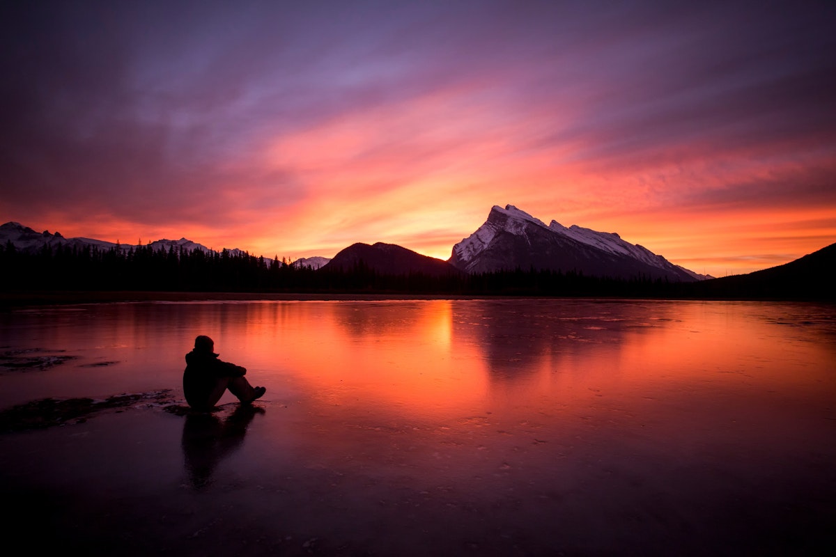 Man watching the sunrise at Vermillion Lakes, Banff National Park, Alberta, Canada