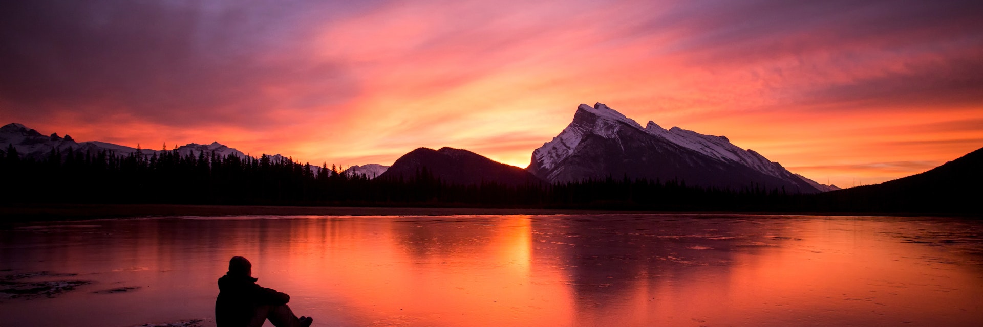 Man watching the sunrise at Vermillion Lakes, Banff National Park, Alberta, Canada