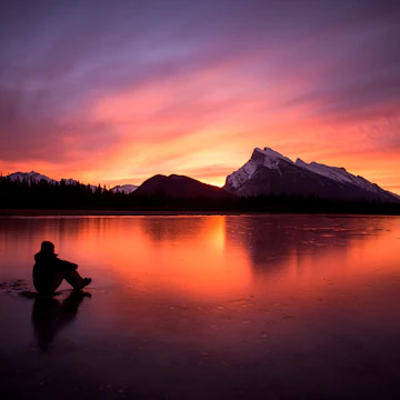 Man watching the sunrise at Vermillion Lakes, Banff National Park, Alberta, Canada